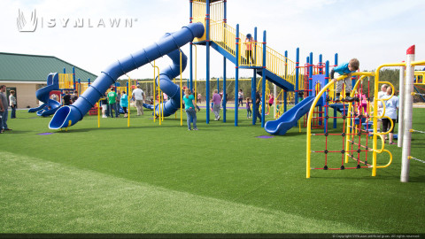 Blue slide installed on artificial playground grass