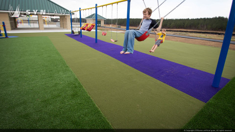 children on playground playing on artificial grass lawn