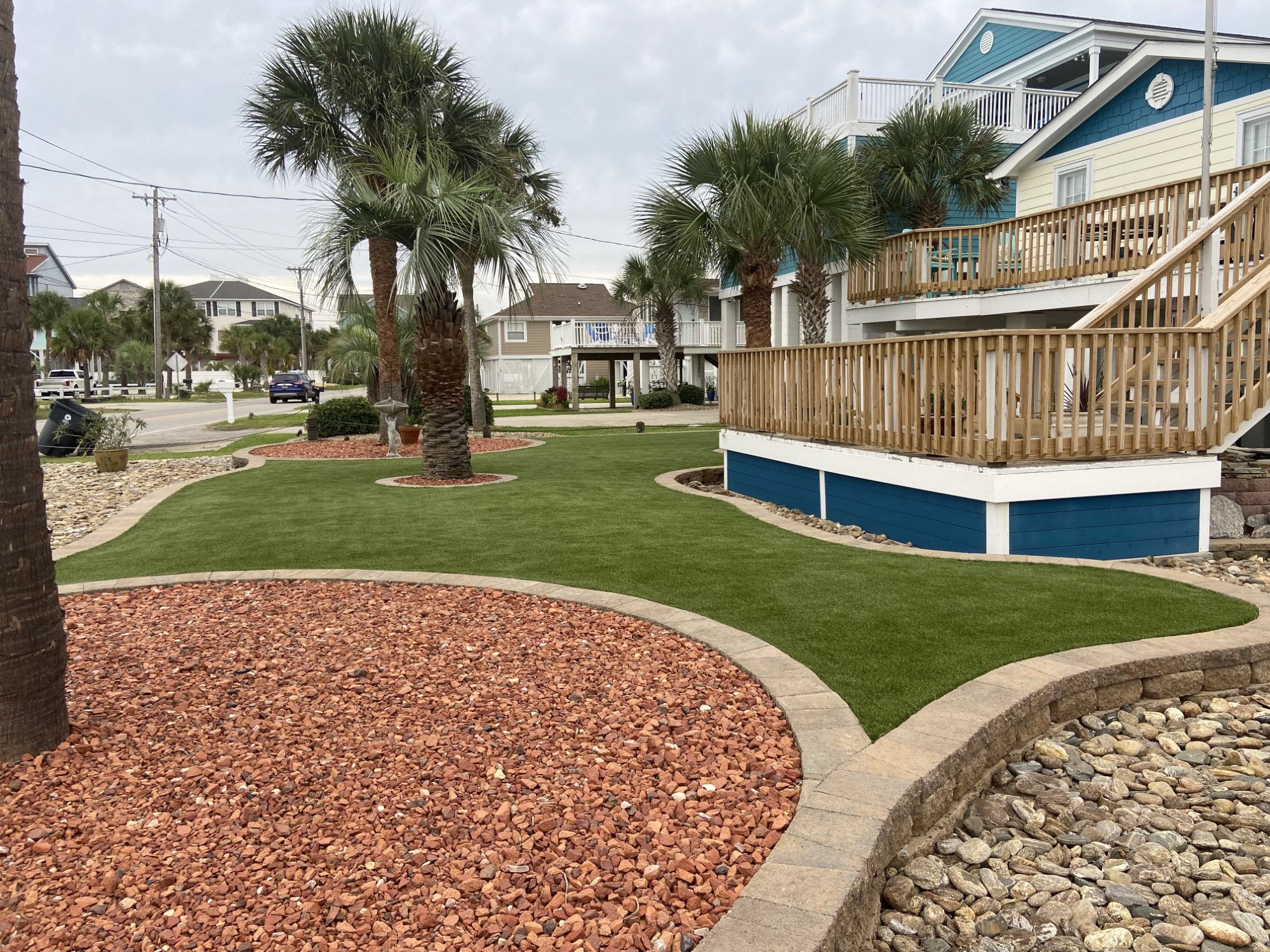 Artificial grass front yard area with blue house